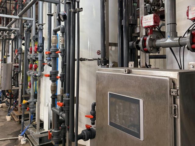 Mueller demineralizer exchange-tank train with stainless and PVC manifold piping serving a high-pressure steam system