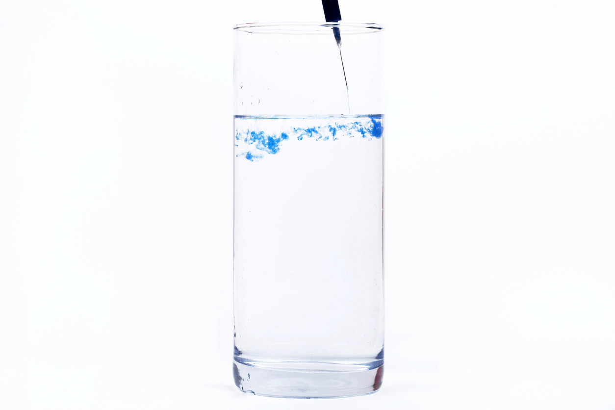 Glass of yellow tinted water showing color contamination
